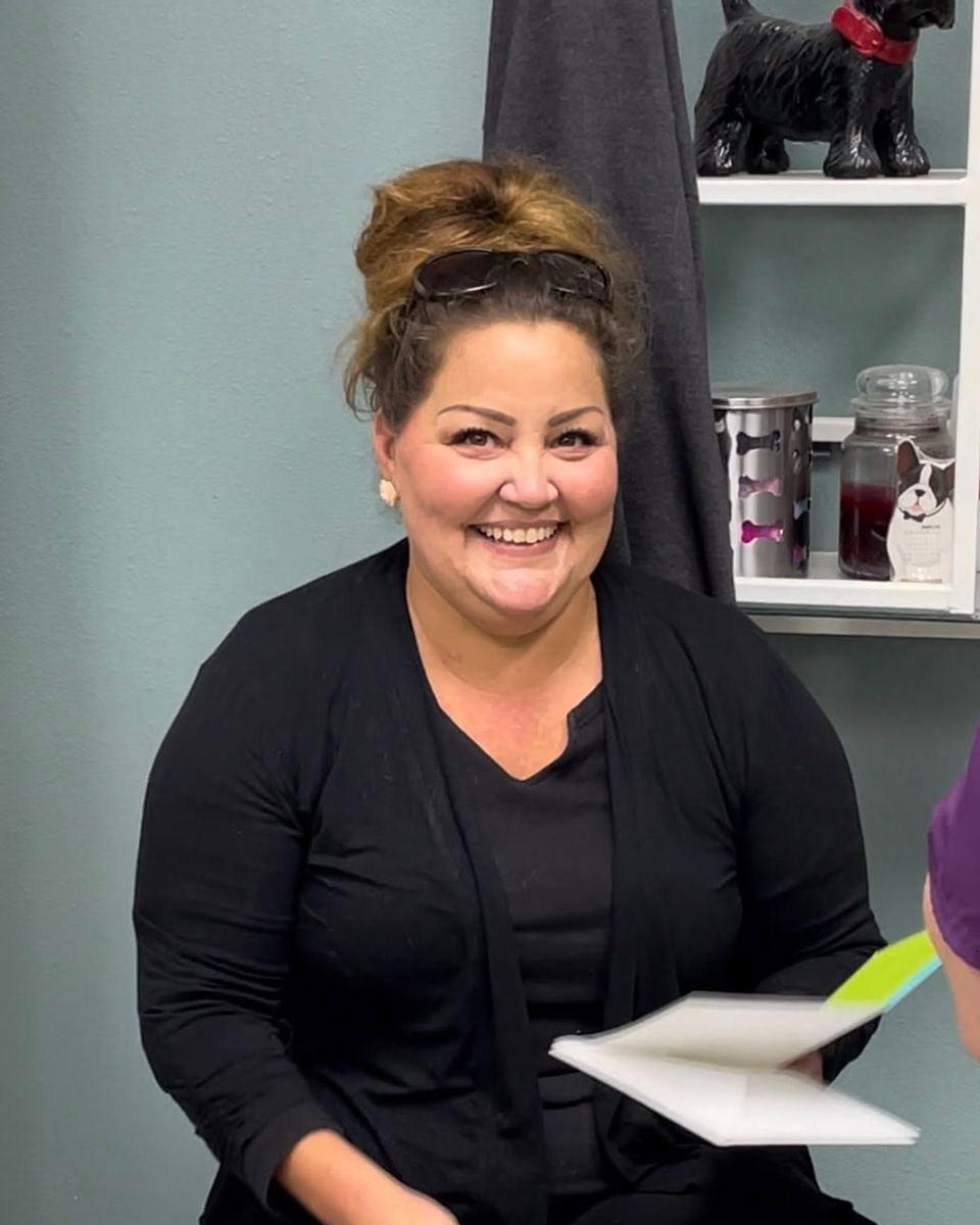 Staff portrait woman smiling holding paper in salon